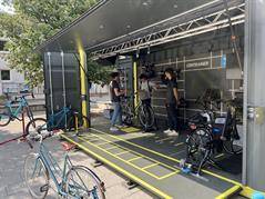 Drei junge Männer stehen an einem Informationsstand der Techniker Krankenkasse zum Thema Fahrrad